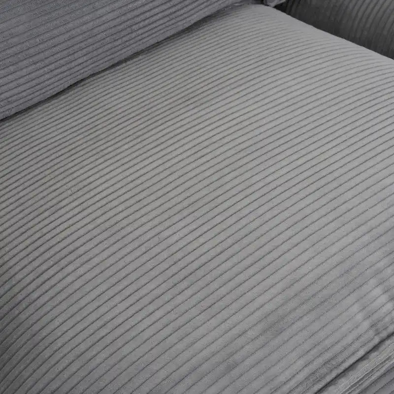 Canapé d'angle avec pouf amovible, en velours côtelé, en forme de L, à assise profonde, avec coussins lombaires et poches latérales.