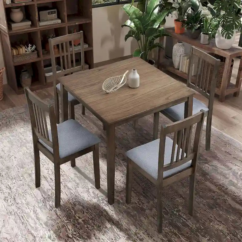 Ensemble table et chaises pour coin repas dans la cuisine : table carrée en bois avec 4 chaises rembourrées.