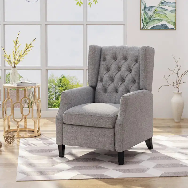 Fauteuil inclinable à oreilles de style mid-century, revêtu de tissu gris, avec repose-pieds et dossier capitonné.